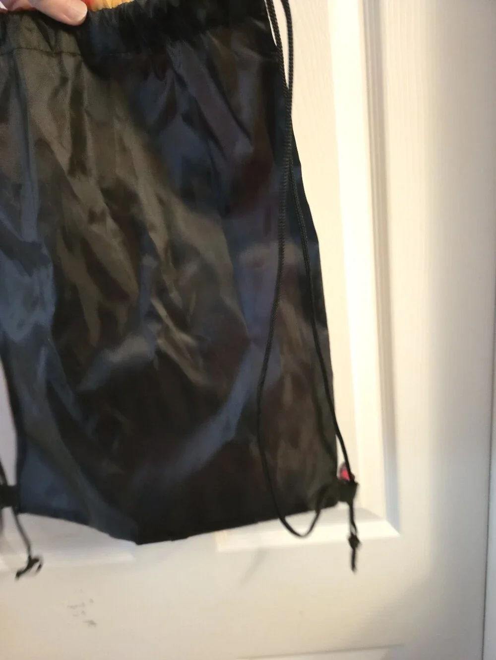 Draw string backpack with a tie dye front print that reads color our world